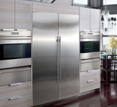 a kitchen with stainless steel appliances and wooden floors