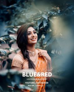 a beautiful woman in an orange sari posing for the camera with her hand on her shoulder