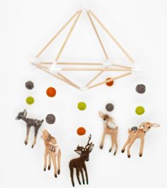 a group of deer and other animals made out of popsicle sticks on a white surface