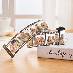 a couple of photos being held up to film strips on top of a table next to a cup and saucer