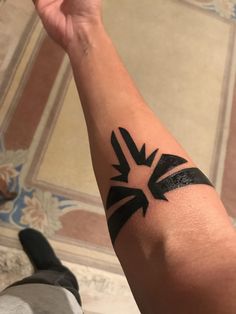 a person's arm with a black tattoo on it and an arrow in the middle