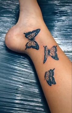 a woman's foot with three butterflies on the top and bottom of her leg