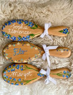 three wooden spoons decorated with blue flowers and the words, sophhe terrence flo margot