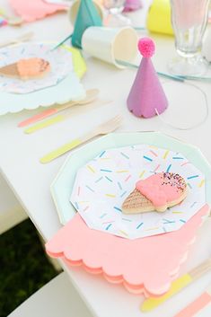 an ice cream cone and sprinkle covered cookie on a paper plate at a birthday party