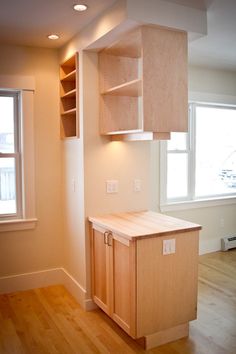 an empty kitchen with wooden cabinets and hard wood floors