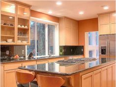 a kitchen with an island and two chairs in front of the counter top, next to a window