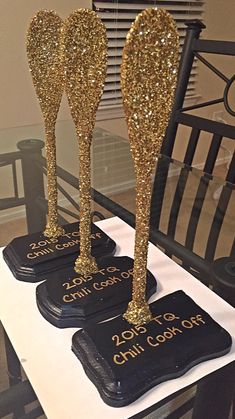 three black coasters with gold glitter on them sitting on a table in front of a window