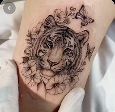 a tiger with flowers and butterflies around it's head on the leg, next to a butterfly