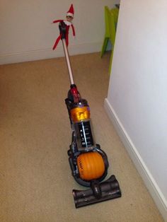 an orange and black vacuum cleaner on the floor