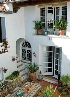 a white house with lots of windows and plants