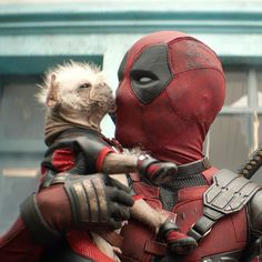 two deadpool characters are hugging each other in front of a building and one is dressed as a hedgehog