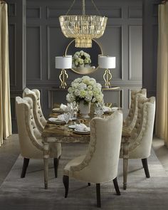 an elegant dining room with chandelier, chairs and flowers in the center table