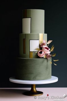 a multi - tiered cake with flowers on the top is green and has gold accents