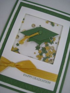 a green and white graduation card with a yellow ribbon on it's side, decorated with gold confetti