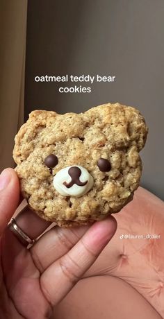 someone is holding up a cookie shaped like a teddy bear