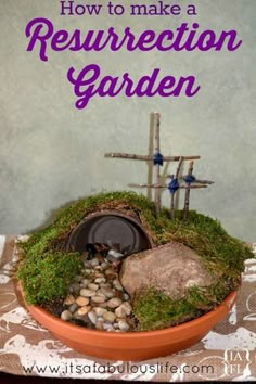 a bowl filled with rocks and moss next to a cross