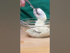 a person scooping something out of a bowl with a spoon