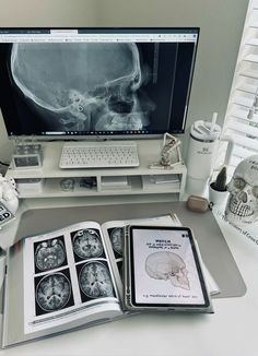 an open book sitting on top of a desk next to a computer