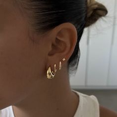 a close up of a person wearing some kind of gold earring on their ear