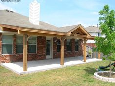 a brick house with an attached porch and swing set