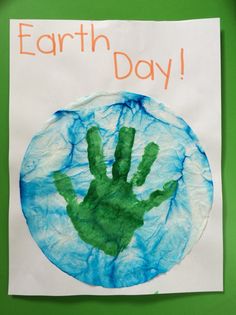 a paper plate with a handprint on it and the words earth day written in orange