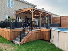 a backyard with a hot tub and deck next to a fenced in pool area