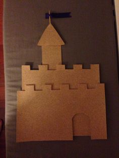 a castle made out of cardboard sitting on top of a wooden table next to a wall