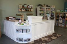 the inside of a store with many items on display and in front of it is a large white counter