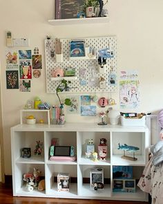 a white shelf with pictures and toys on it