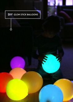 a little boy standing in front of some glowing balls