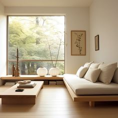 a living room filled with furniture next to a large window covered in lots of trees