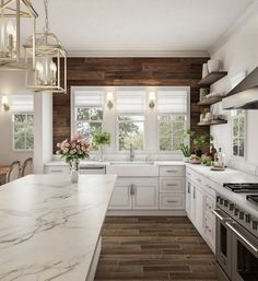 a large kitchen with marble counter tops and white cabinets, along with wood paneling on the walls