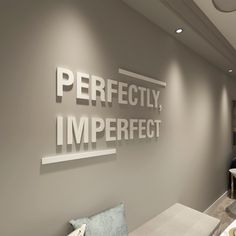 the interior of an office with white and gray decor on the walls, along with large letters that spell out perfectly imperfect