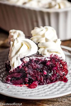 a slice of blueberry pie on a plate with meringue and whipped cream