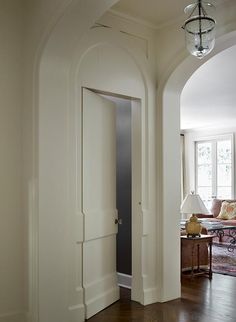 an archway leading into a living room with wood floors