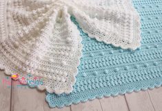 a crocheted baby blanket on the floor