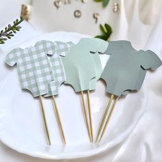 three green and white paper animals on toothpicks