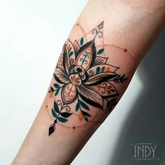 a woman's arm with a flower tattoo on it