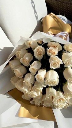 a bouquet of white roses is wrapped in paper