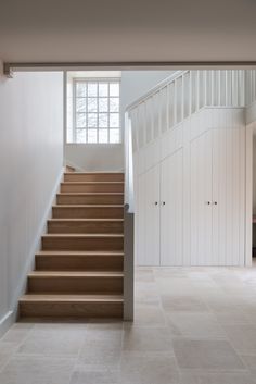 an empty room with stairs leading up to the second floor and closets on either side