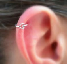 a close up of a person's ear with a small heart on it