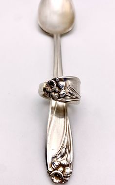 a silver spoon with two flowers on it