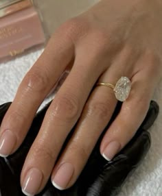 a close up of a person's hand with a ring on it