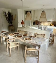 a dining room table and chairs with plates on it