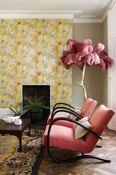 a living room filled with furniture and a fire place in front of a floral wallpaper