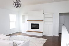 a living room with white furniture and a fireplace