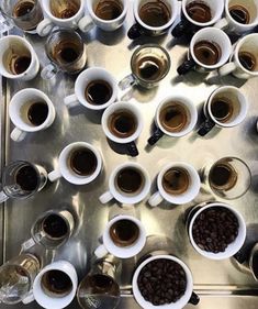 several cups of coffee are arranged on a metal tray