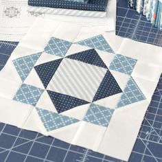 a quilter's work table with blue and white material on it, including two pieces of fabric