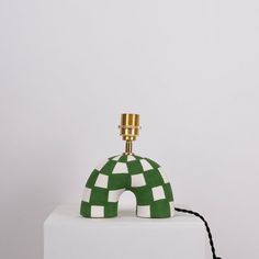 a green and white lamp sitting on top of a white block