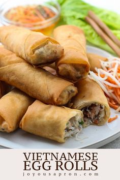 vietnamese egg rolls on a plate with coleslaw and carrots in the background